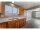 Kitchen featuring wood cabinets and a stainless steel sink overlooking a living area at 3802 Terrazzo Ave, Las Vegas, NV 89115