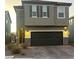 Two-story house with gray exterior, dark garage door, and landscaping at 5773 Holbeche St, Las Vegas, NV 89113