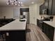 Modern kitchen with island, stainless steel appliances, and dark cabinetry at 5773 Holbeche St, Las Vegas, NV 89113