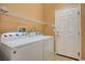 Laundry room with Whirlpool washer and dryer and overhead shelving at 5908 Aqua Verde St, North Las Vegas, NV 89031