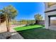 Artificial turf backyard with block wall and trees at 712 Rogue Wave St, Las Vegas, NV 89138