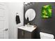 Modern powder room with a round mirror, dark vanity, and stylish decor at 8535 Black Brush Ln, Las Vegas, NV 89131