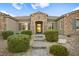 Inviting front entrance with a stone facade and lush landscaping at 8535 Black Brush Ln, Las Vegas, NV 89131