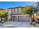 Two-story house with gray siding, stone accents, and a three-car garage at 87 Newton Ridge Way, Las Vegas, NV 89183