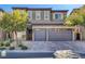 Two-story house with gray siding, stone accents, and a three-car garage at 87 Newton Ridge Way, Las Vegas, NV 89183