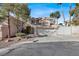 Two-story house with a tan exterior, two-car garage, and landscaped front yard at 8753 Arawana Pl, Henderson, NV 89074