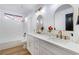 Double vanity bathroom with marble countertop and arched mirrors at 9 White Tail Ct, Henderson, NV 89074