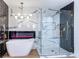 Modern bathroom with marble walls, soaking tub, and glass shower at 9 White Tail Ct, Henderson, NV 89074