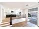 Modern kitchen with island, white cabinets, and a backyard view at 9 White Tail Ct, Henderson, NV 89074