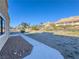 Large backyard with gravel landscaping, concrete path, and mountain views at 1032 Morning Sun Way, Las Vegas, NV 89110