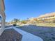 Large backyard with gravel landscaping, concrete path, and mountain views at 1032 Morning Sun Way, Las Vegas, NV 89110