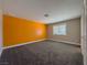 Bedroom with gray carpet and an orange accent wall at 1032 Morning Sun Way, Las Vegas, NV 89110