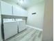 Well-lit laundry room with washer, dryer and cabinets at 1032 Morning Sun Way, Las Vegas, NV 89110