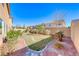 Landscaped backyard with grass, stone pathway, and desert landscaping at 10598 Aphrodite St, Las Vegas, NV 89183