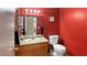 Small bathroom with wood vanity, toilet and red walls at 3350 Stacey Lyn Dr, Las Vegas, NV 89117