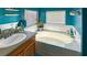 Bathroom with teal walls, single sink vanity, and oval tub at 3350 Stacey Lyn Dr, Las Vegas, NV 89117