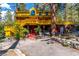Yellow two-story house with wrap-around deck, red stairs, and mature trees at 362 Rainbow Canyon Blvd, Las Vegas, NV 89124