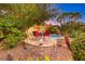 Stone patio with seating area near the pool and lush landscaping at 38 Benevolo Dr, Henderson, NV 89011