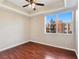 A bright bedroom with dark wood floors, a ceiling fan, and a large window at 43 E Agate Ave # 403, Las Vegas, NV 89123
