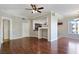 Spacious living room showcasing hardwood floors, crown molding, ceiling fan, and an open layout leading to the kitchen at 43 E Agate Ave # 403, Las Vegas, NV 89123