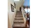 Carpeted staircase with wooden railing and wall decor at 6329 Kitamaya St, North Las Vegas, NV 89031