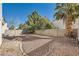 Landscaped backyard with gravel, mature trees, and a block wall at 7808 License St, Las Vegas, NV 89131
