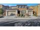 Two-story house with stone accents and a three-car garage at 824 Bluebird Hill Ave, North Las Vegas, NV 89084