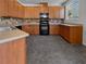 U-shaped kitchen with wood cabinets and black appliances at 10375 Beallsville St, Las Vegas, NV 89141