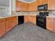 Kitchen with wood cabinets, black appliances, and tile floor at 10375 Beallsville St, Las Vegas, NV 89141