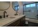 Double vanity bathroom with dark wood cabinets and a large walk in shower at 10744 Balsam Creek Ave, Las Vegas, NV 89144