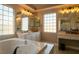 Spa-like bathroom featuring a soaking tub, double vanity, and large windows at 10744 Balsam Creek Ave, Las Vegas, NV 89144