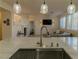 Kitchen with island, stainless steel sink, and view into living room at 10744 Balsam Creek Ave, Las Vegas, NV 89144