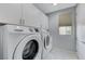 Laundry room with white washer, dryer, and gray cabinets at 11377 Gravitation Dr, Las Vegas, NV 89135