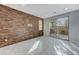 Bright living room featuring wood accent wall, tile flooring, and sliding glass door to backyard at 11377 Gravitation Dr, Las Vegas, NV 89135