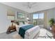 Staged main bedroom boasts neutral carpet, a large window, and sliding glass door to balcony at 11377 Gravitation Dr, Las Vegas, NV 89135