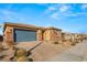 Modern single story home with gray garage door and stone accents at 1282 Paseo Del Oso Ln, Henderson, NV 89002