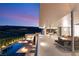 Expansive balcony view showcasing the pool, outdoor lounge, and mountain backdrop at dusk at 14 Magic Stone Ln, Las Vegas, NV 89135