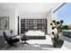 Modern main bedroom features an accent wall with built-in shelving and seamless access to outdoor space and natural light at 14 Magic Stone Ln, Las Vegas, NV 89135