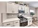 Modern kitchen with white cabinets, quartz countertops and a gas cooktop at 1664 Hartley Ave, Henderson, NV 89052