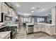 Spacious kitchen with white cabinets, quartz countertops, and stainless steel appliances at 1664 Hartley Ave, Henderson, NV 89052