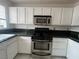 Kitchen with white cabinets, granite counters, and gas stove at 2104 Fountain View Dr, Las Vegas, NV 89134