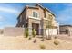 Beige two-story house with stone accents, landscaping, and a driveway at 230 Palisade Falls Ave, Henderson, NV 89015