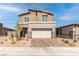 Two-story house with beige exterior, stone accents, and a paved driveway at 230 Palisade Falls Ave, Henderson, NV 89015