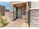 Modern front entrance with gray stone pillars and a light gray door at 230 Palisade Falls Ave, Henderson, NV 89015