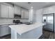 Modern kitchen with gray cabinets, white countertops, and stainless steel appliances at 230 Palisade Falls Ave, Henderson, NV 89015