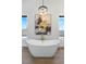 Bathroom with freestanding tub, natural light, and modern chandelier at 311 Belfast St, Henderson, NV 89015