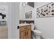 Powder room with wood vanity, toilet and decorative wall art at 311 Belfast St, Henderson, NV 89015