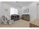 Bedroom with crib, rocker, dresser, and window with curtains at 311 Belfast St, Henderson, NV 89015