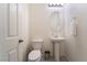 Small bathroom with pedestal sink, toilet, and oval mirror at 406 Misterioso St, Henderson, NV 89011