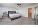 Main bedroom with large bed, ceiling fan, and gray carpet at 406 Misterioso St, Henderson, NV 89011